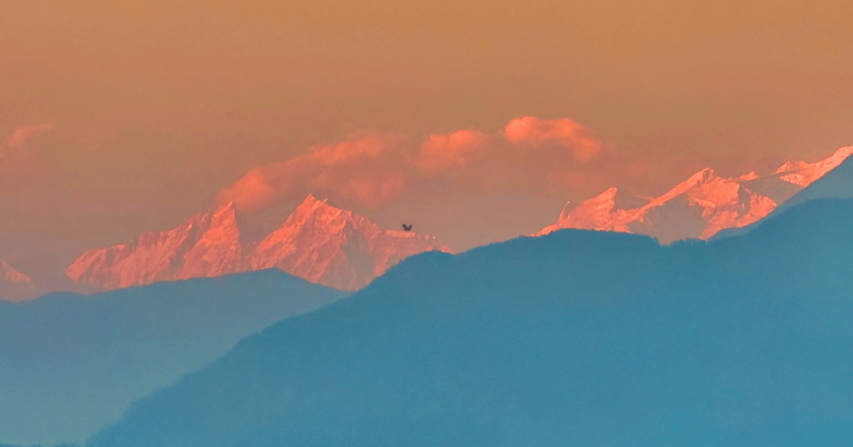 November 14, 2025 — alpenglow on the Narayanghat northern horizon. The triangular peak on the left glows orange-red.